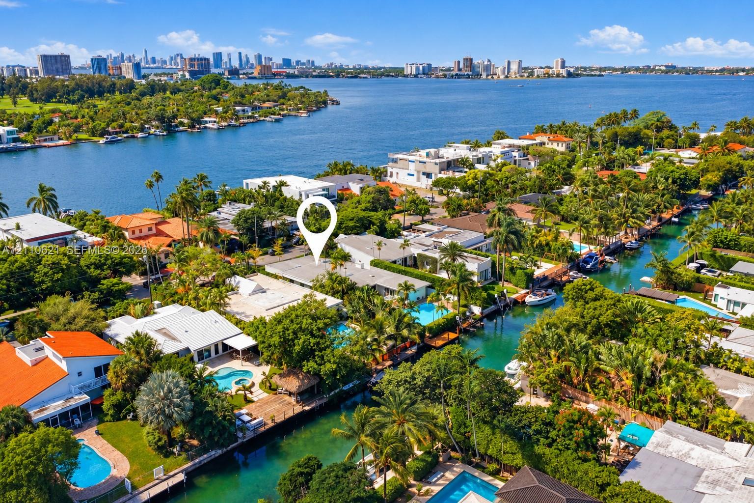 Aerial perspective of a waterfront property featuring a private swimming pool, deep-water canal access, and mature landscaping Aerial perspective of a waterfront property featuring a private swimming pool, deep-water canal access, and mature landscaping