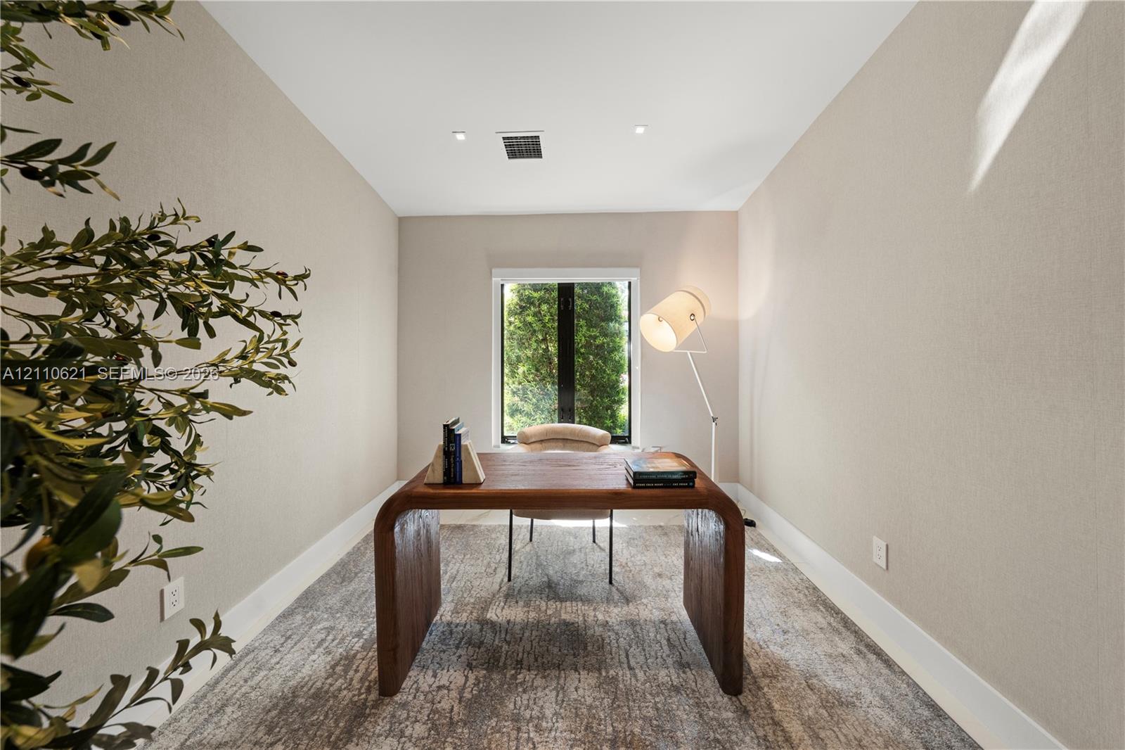 Neutral-toned wall finishes, recessed ceiling lighting, and a single-pane window with a black frame