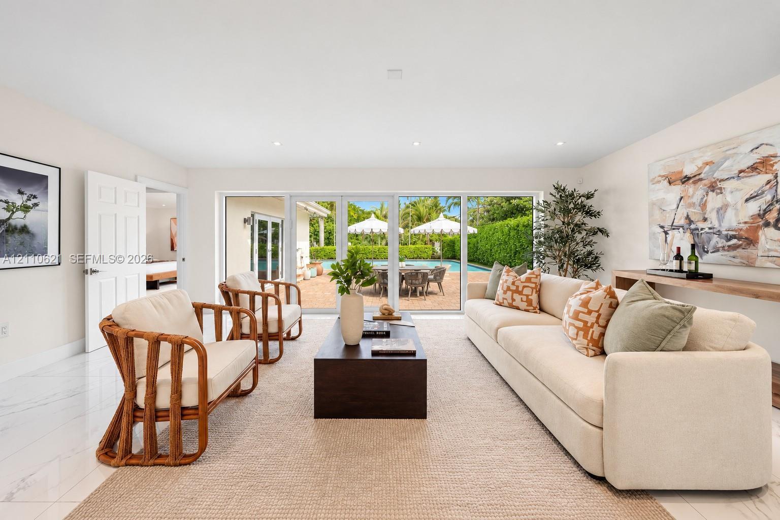 Living area featuring large-format polished flooring, recessed lighting, and multi-panel glass doors opening to a paved patio and pool area