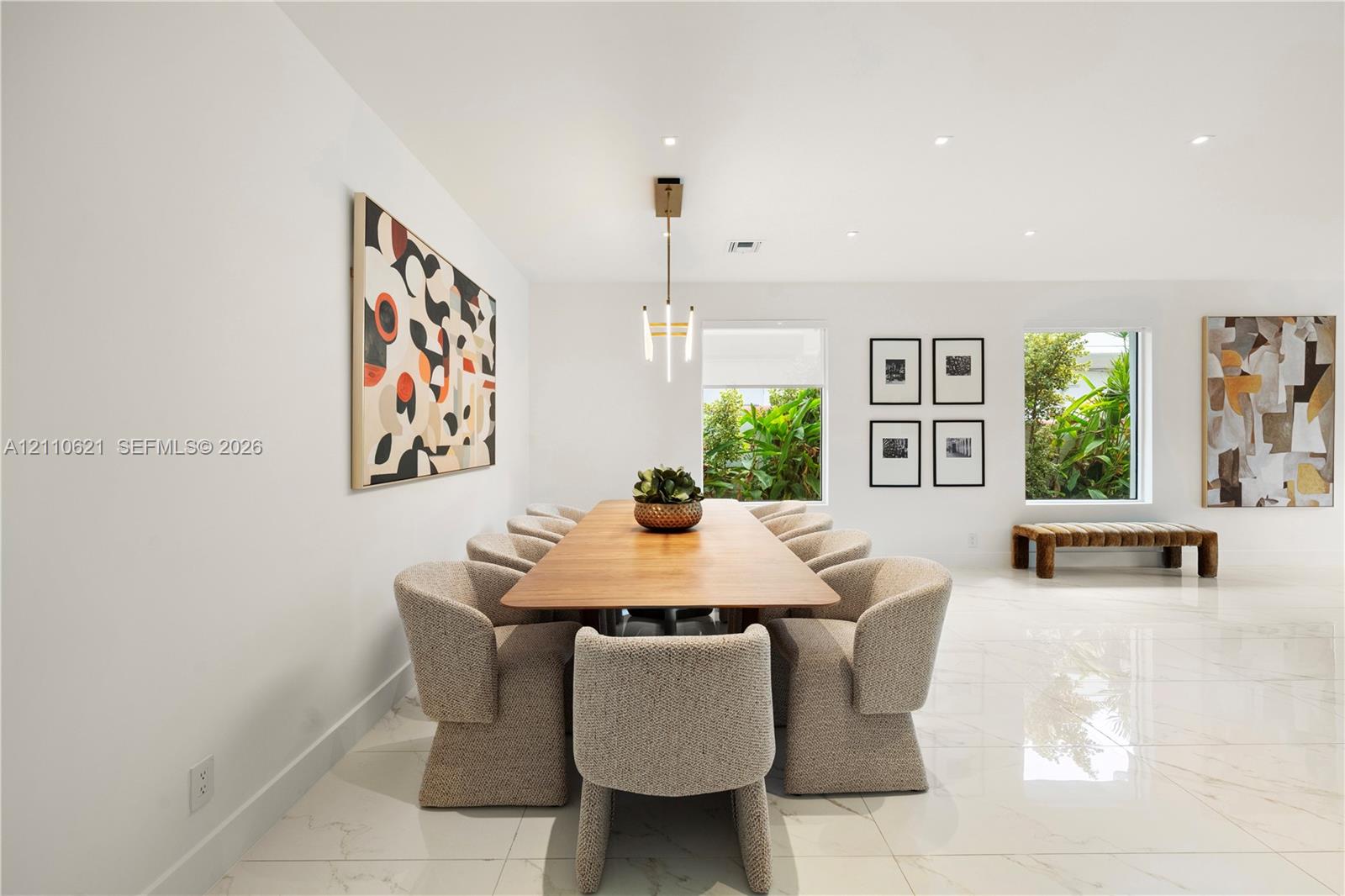 Large-format polished tile flooring, recessed ceiling lighting, and a modern tiered chandelier