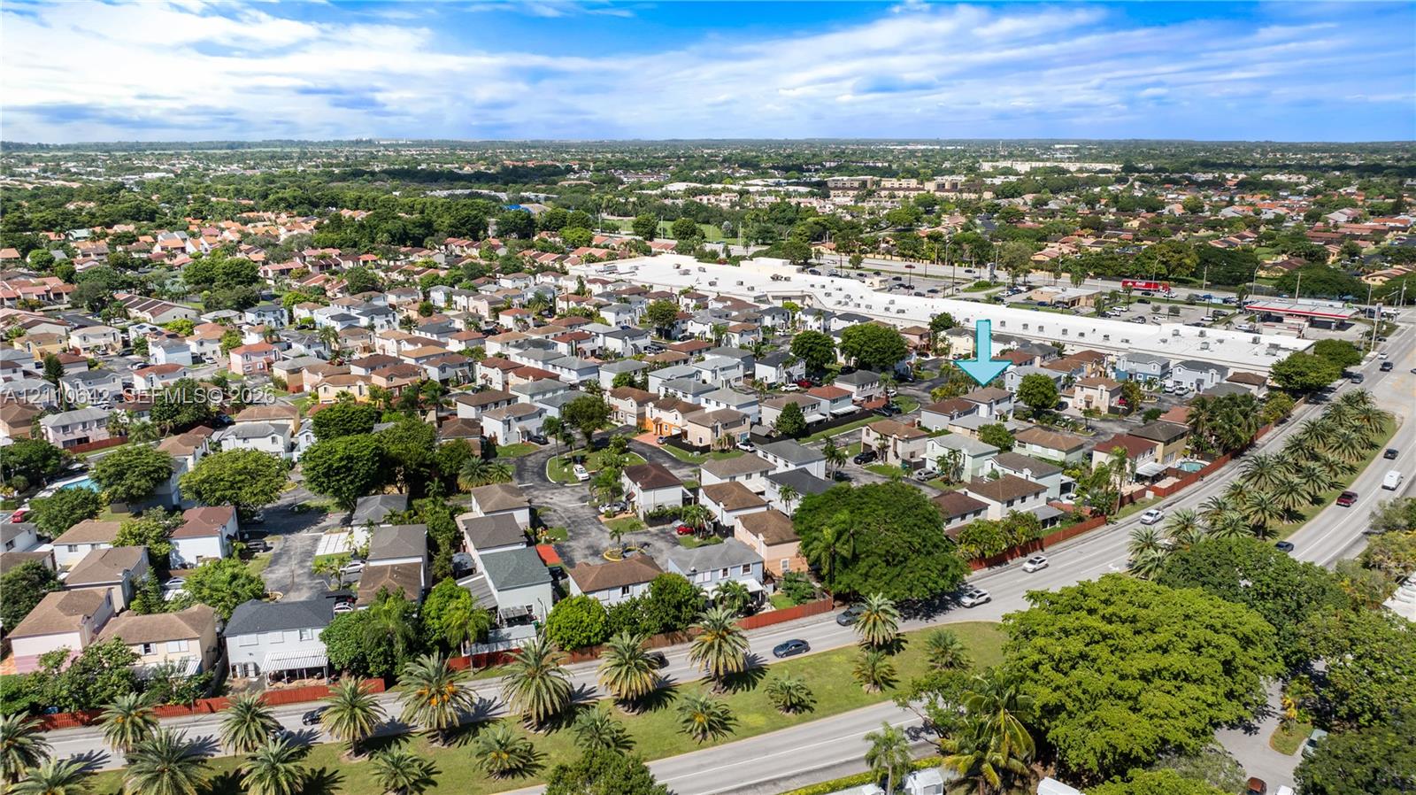 Aerial perspective of a suburban neighborhood featuring residential housing, mature tree canopy coverage, expansive green spaces, and proximity to major thoroughfares
