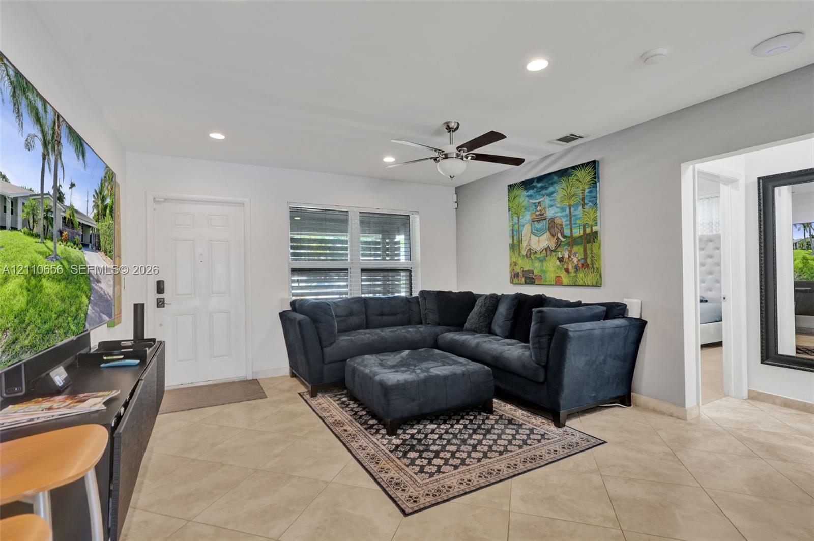 Neutral ceramic tile flooring, recessed lighting, multi-blade ceiling fan, and horizontal window blinds