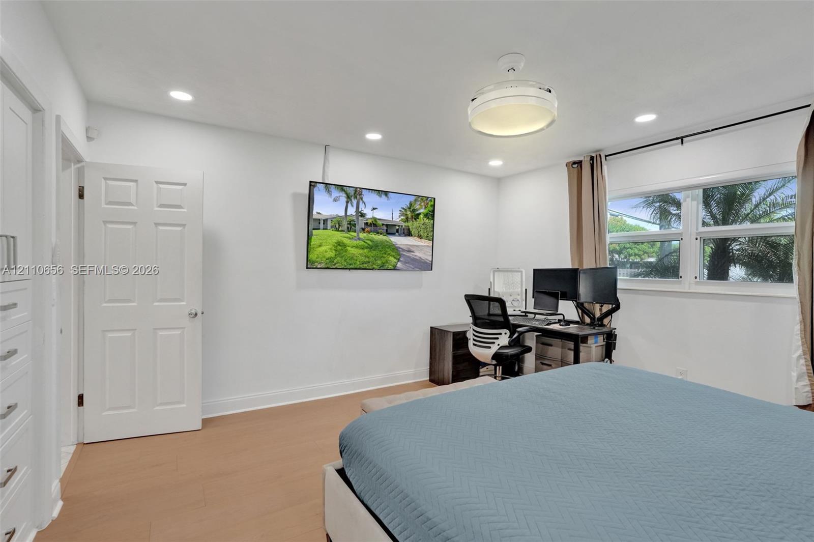 Room featuring wood-finish flooring, recessed lighting, a modern ceiling fixture, and a built-in cabinet