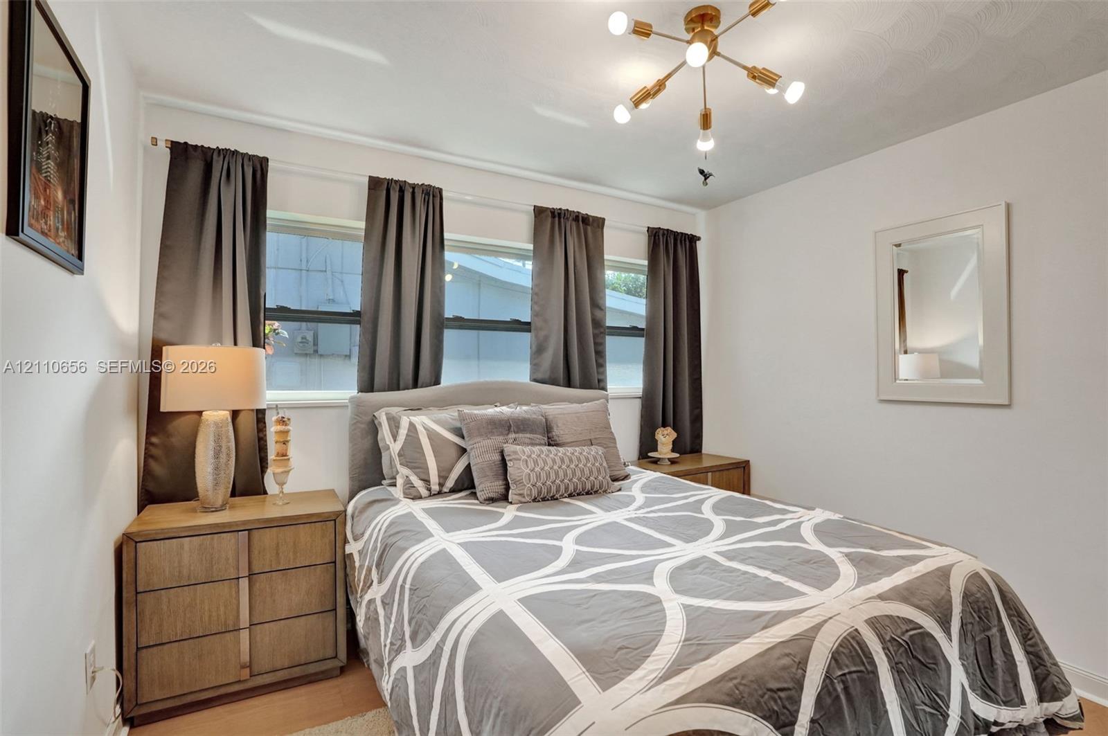 Multi-pane windows, brass-finish Sputnik-style chandelier, and neutral wall tones