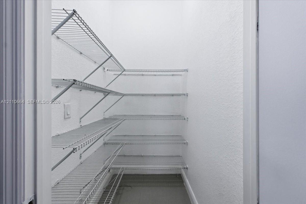 Walk-in storage pantry with multi-tiered wire shelving for convenient organization