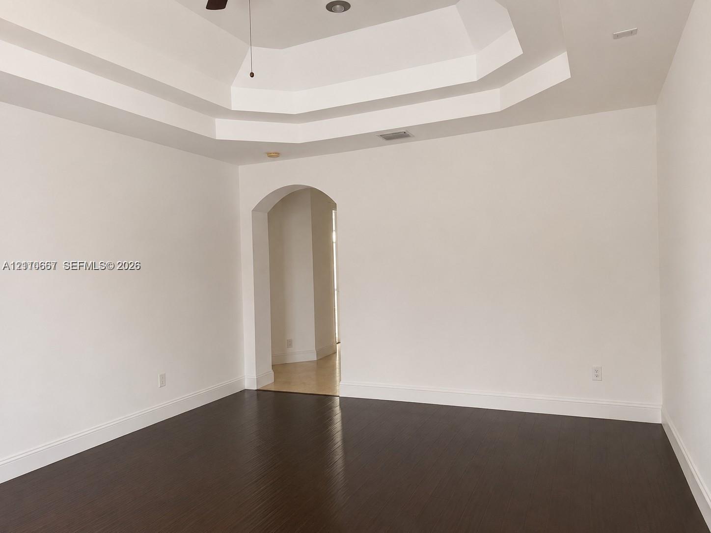 Walk-in closet featuring custom wood-finish built-in shelving, hanging rods, and wood-finish flooring
