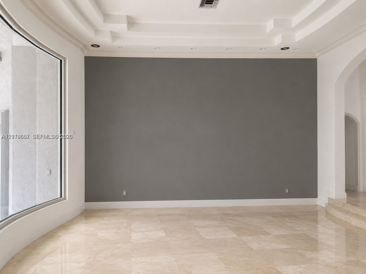 Custom tray ceiling with tiered architectural detailing, integrated recessed lighting, and arched passage entryways