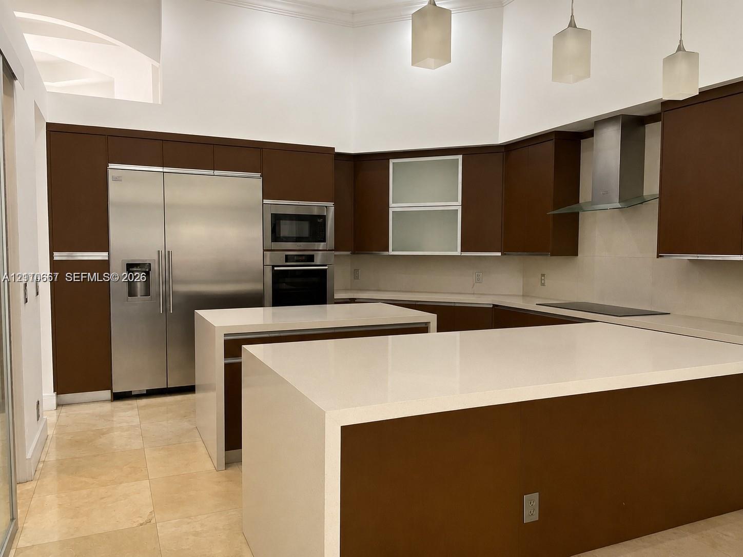 Large bay windows featuring expansive glass panels, stone-finish tile flooring, and direct exterior exposure to a swimming pool and landscaped grounds