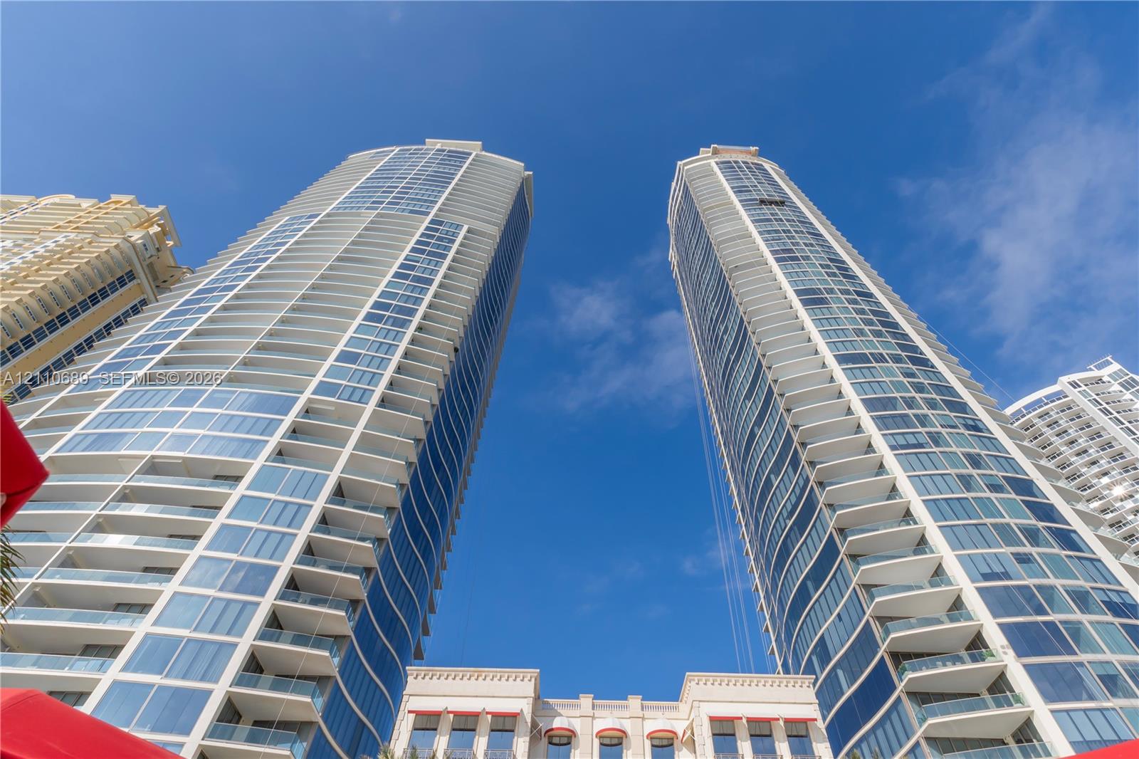 High-rise residential towers featuring blue-tinted glass curtain walls, white structural balconies, and tiered architectural detailing