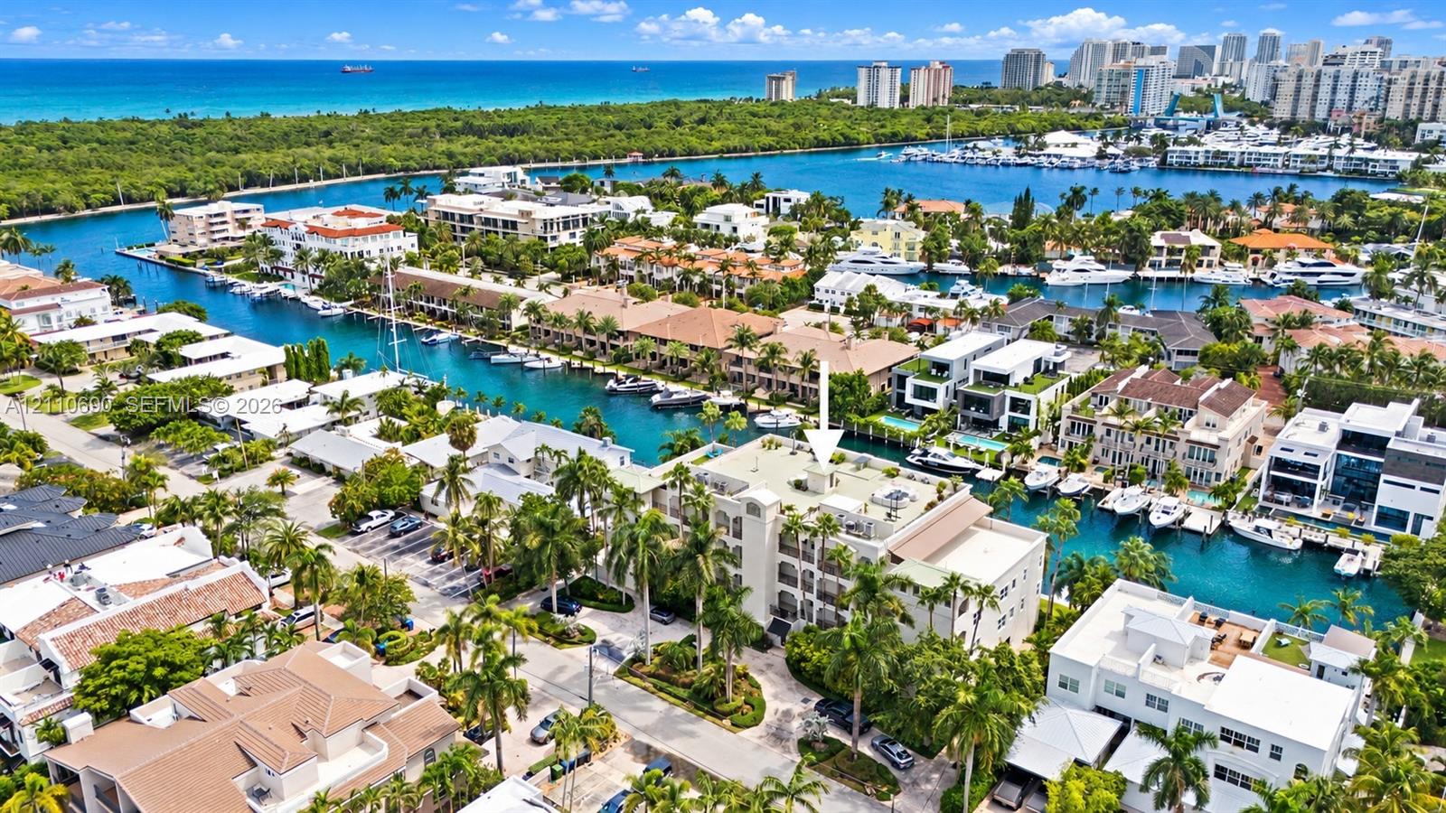 Aerial view showcasing a waterfront community with multiple residences featuring turquoise-water canals, mature palm trees, and lush landscaping throughout the neighborhood Aerial view showcasing a waterfront community with multiple residences featuring turquoise-water canals, mature palm trees, and lush landscaping throughout the neighborhood