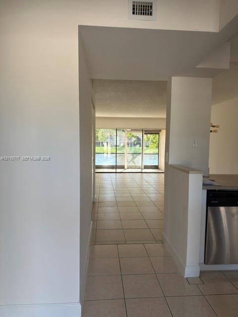 Large ceramic tile flooring, stainless steel dishwasher, and expansive sliding glass doors Large ceramic tile flooring, stainless steel dishwasher, and expansive sliding glass doors