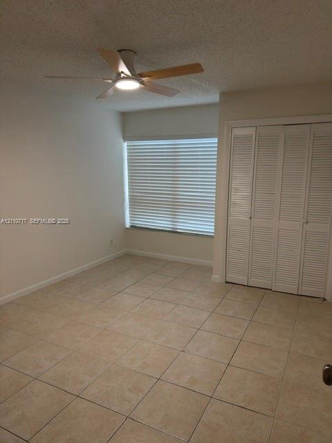 Ceramic tile flooring, white louvered-style closet doors, ceiling fan with integrated lighting, and horizontal window blinds Ceramic tile flooring, white louvered-style closet doors, ceiling fan with integrated lighting, and horizontal window blinds