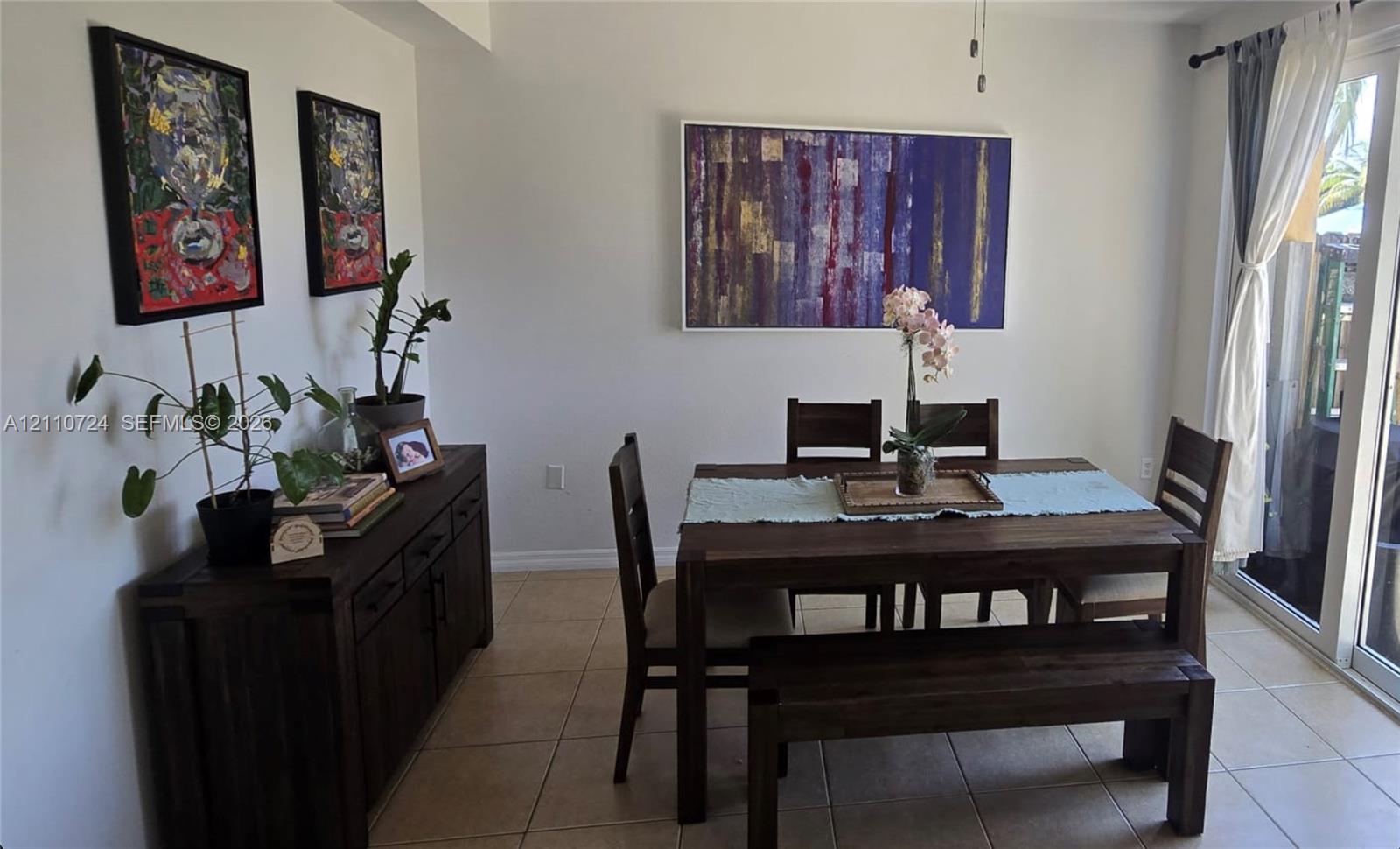 Neutral-toned interior featuring ceramic tile flooring and a sliding glass door providing natural light