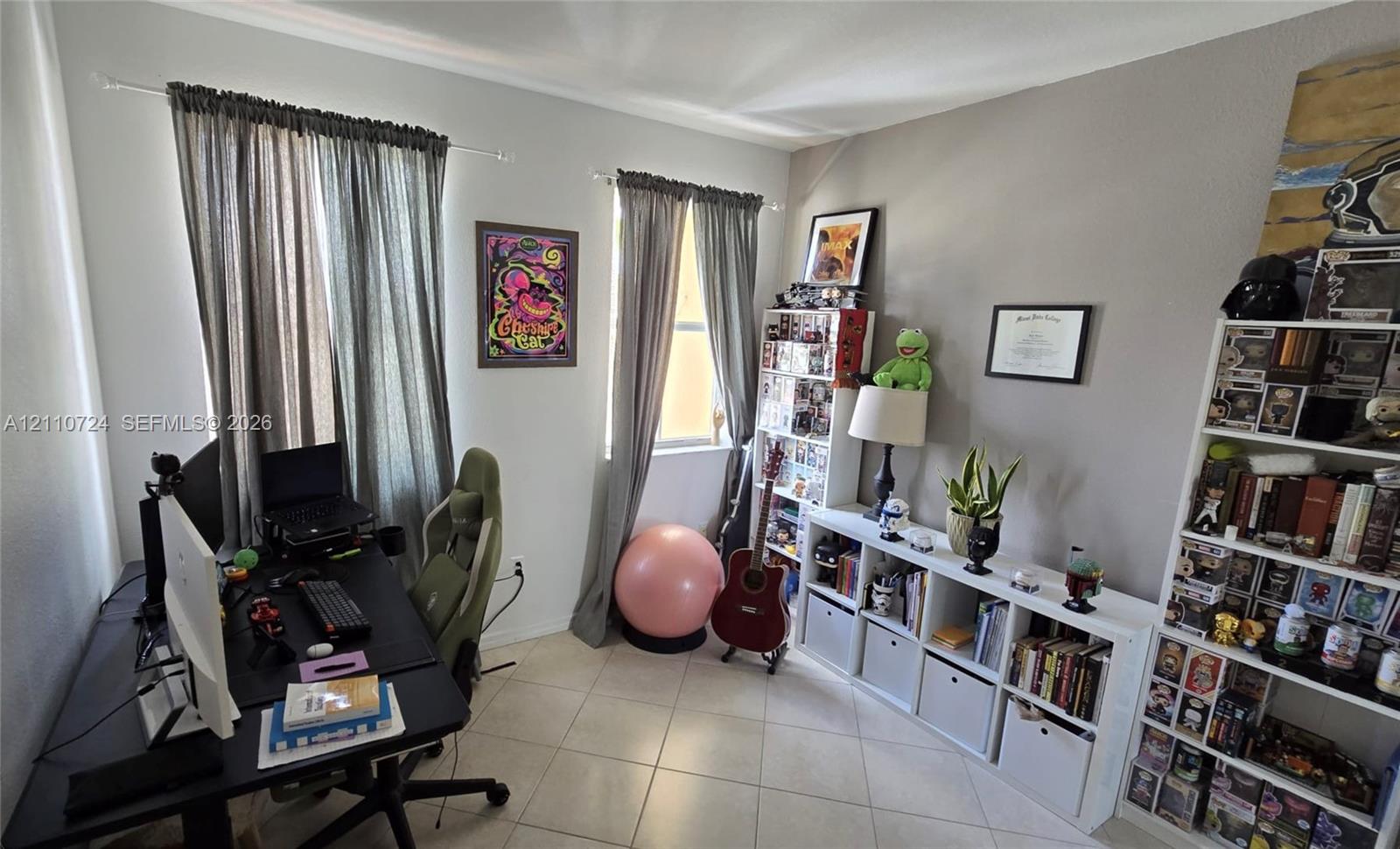 Neutral-toned interior space featuring light-colored tile flooring and dual windows