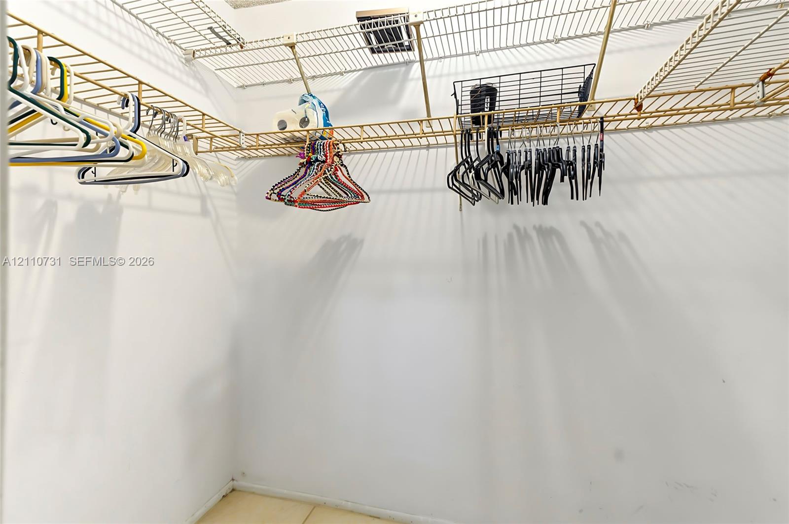 Walk-in storage area featuring white walls and tiered metal wire shelving