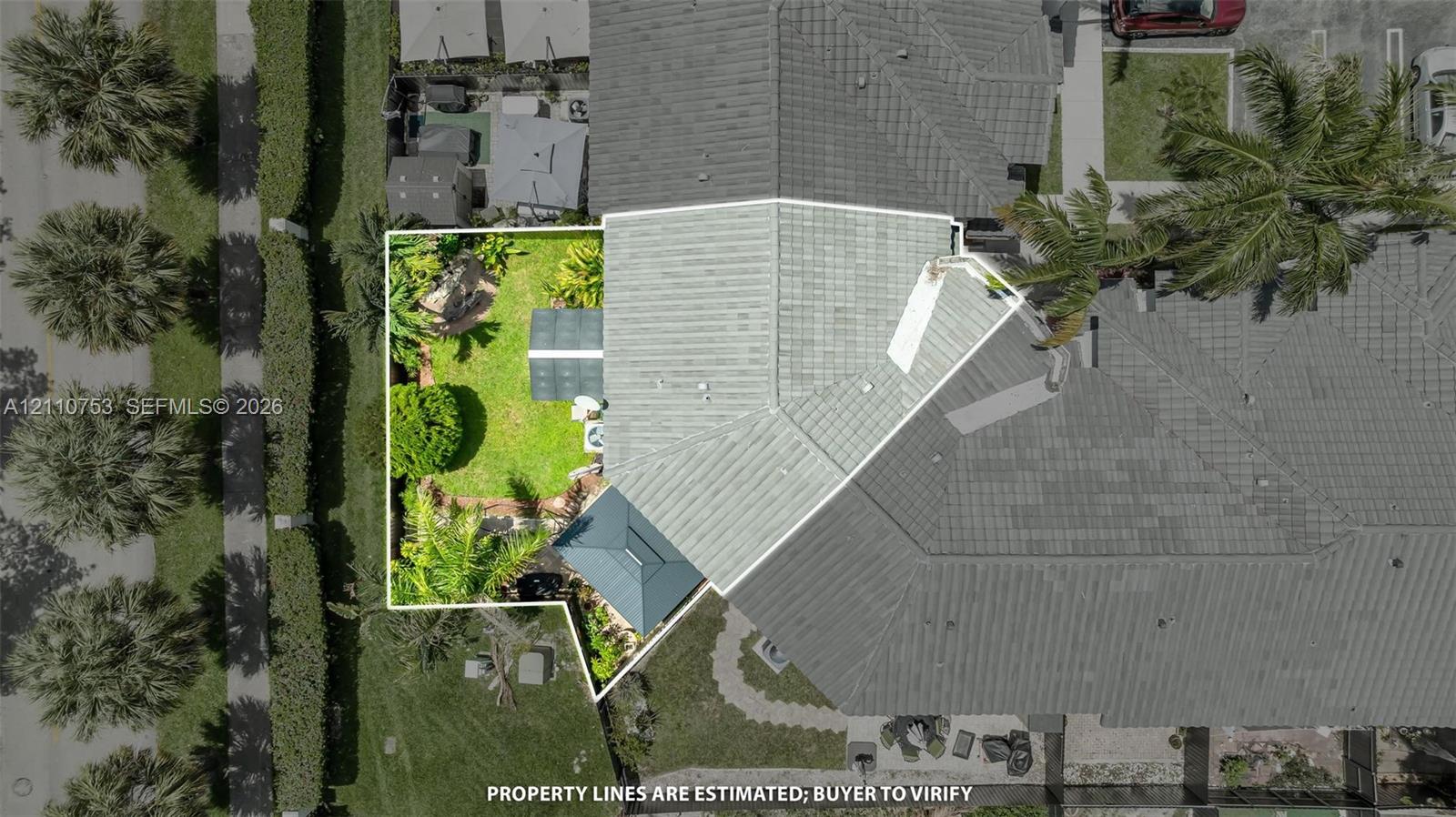 Aerial perspective highlighting a fenced-in yard, paved patio area, green space, and tile roofing