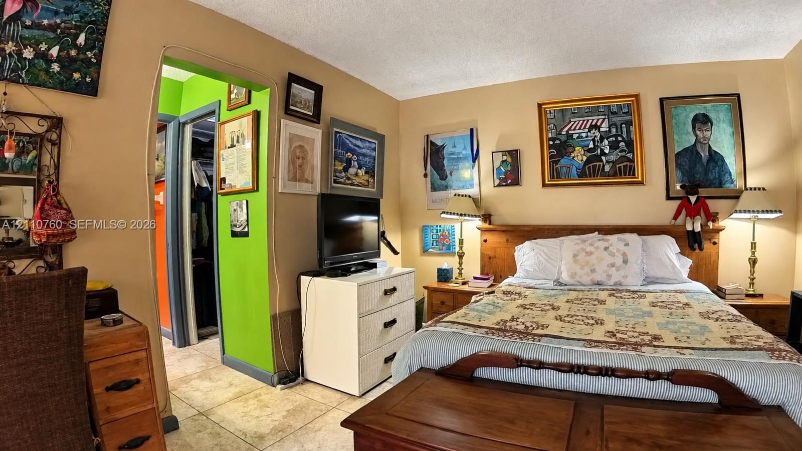 Interior space featuring neutral-toned walls, tile flooring, and a walk-in closet with integrated storage