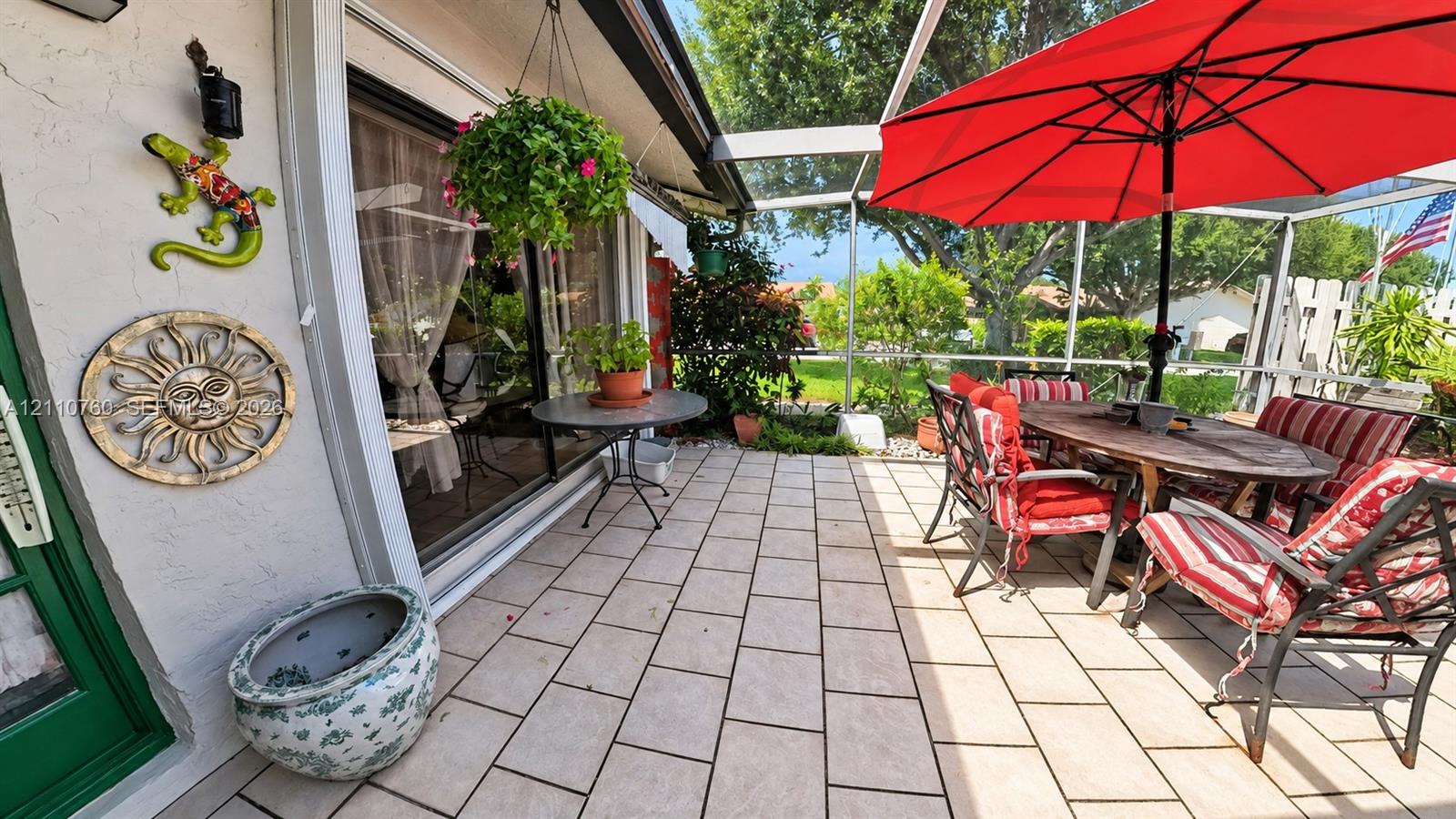 Screened lanai featuring tiled flooring, sliding glass door entry, and outdoor access to the grounds Screened lanai featuring tiled flooring, sliding glass door entry, and outdoor access to the grounds