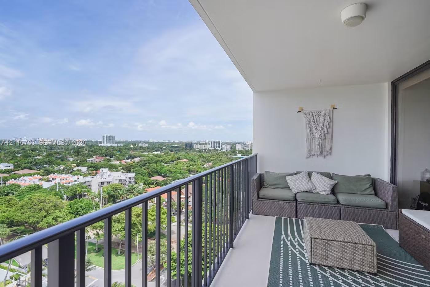 Covered balcony featuring metal railings and a concrete floor