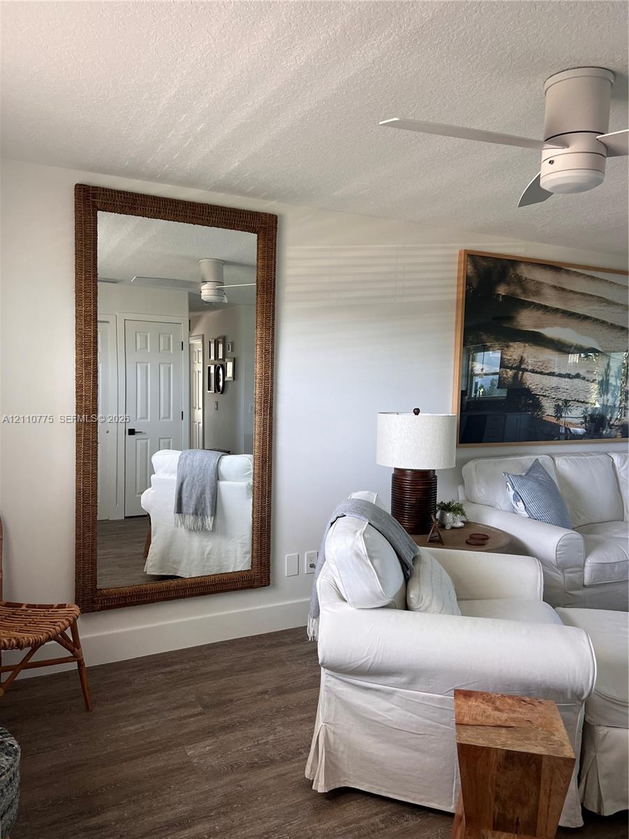 Wood-finish flooring, white paneled interior doors, and modern low-profile ceiling fan
