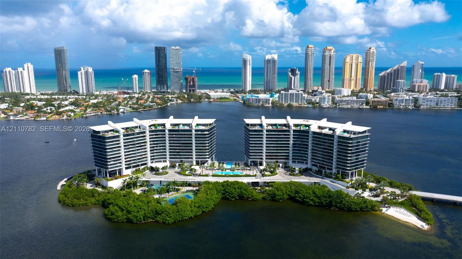 Waterfront high-rise complex situated on a private island, featuring tiered architectural profiles, expansive glass balcony systems, a central outdoor swimming pool, and gated bridge access Waterfront high-rise complex situated on a private island, featuring tiered architectural profiles, expansive glass balcony systems, a central outdoor swimming pool, and gated bridge access