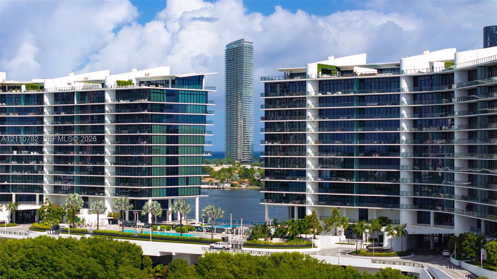 Modern high-rise architecture featuring expansive glass curtain walls, wrap-around balconies, deep-water access, and integrated ground-level swimming pools