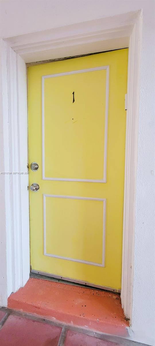 Solid-core door featuring a two-panel design, decorative molding, dual metallic hardware, and a metal threshold Solid-core door featuring a two-panel design, decorative molding, dual metallic hardware, and a metal threshold