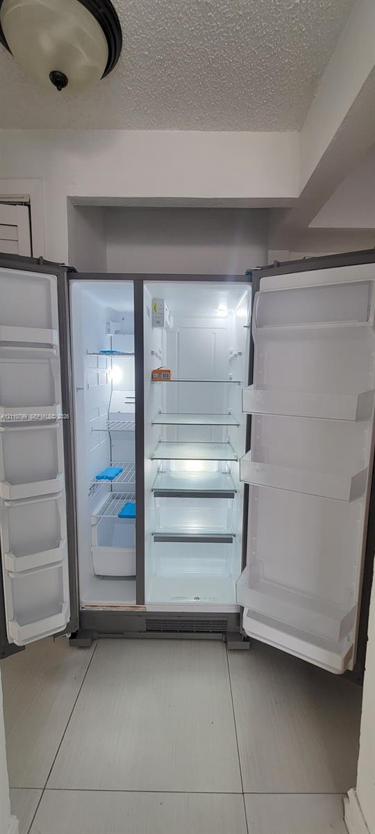 Stainless steel side-by-side refrigerator featuring adjustable glass shelving, clear storage drawers, and integrated door bins Stainless steel side-by-side refrigerator featuring adjustable glass shelving, clear storage drawers, and integrated door bins