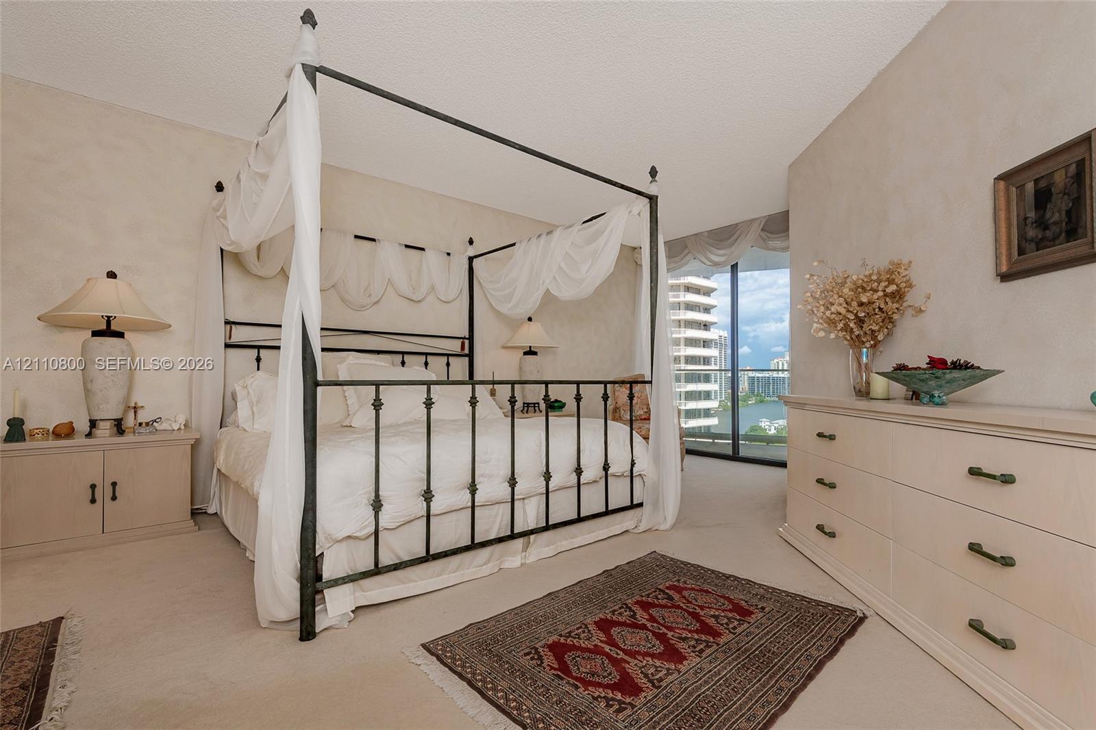 Neutral interior space featuring floor-to-ceiling glass sliding doors, wall-to-wall carpeting, and neutral textured wall finishes