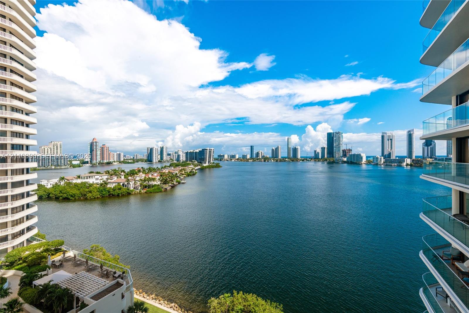 High-rise balconies featuring glass railings, overlooking a large body of water and a metropolitan skyline High-rise balconies featuring glass railings, overlooking a large body of water and a metropolitan skyline