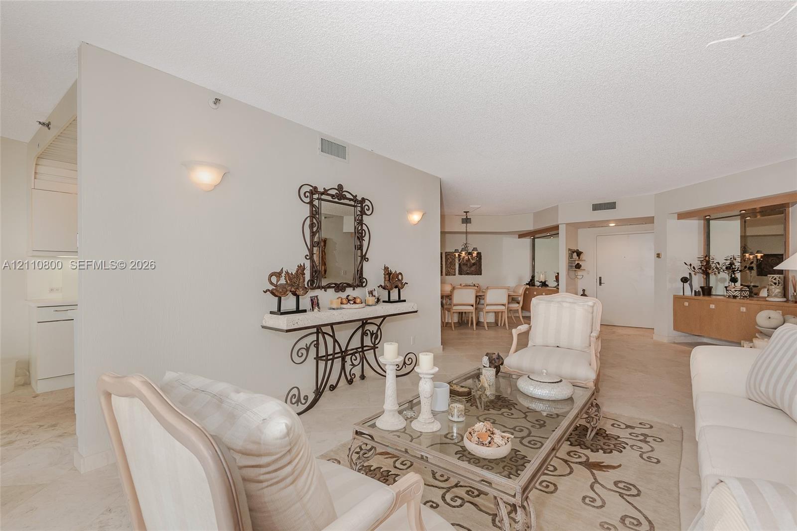 Open-concept interior featuring neutral stone-finish tile flooring, recessed lighting, and wall-mounted sconce fixtures