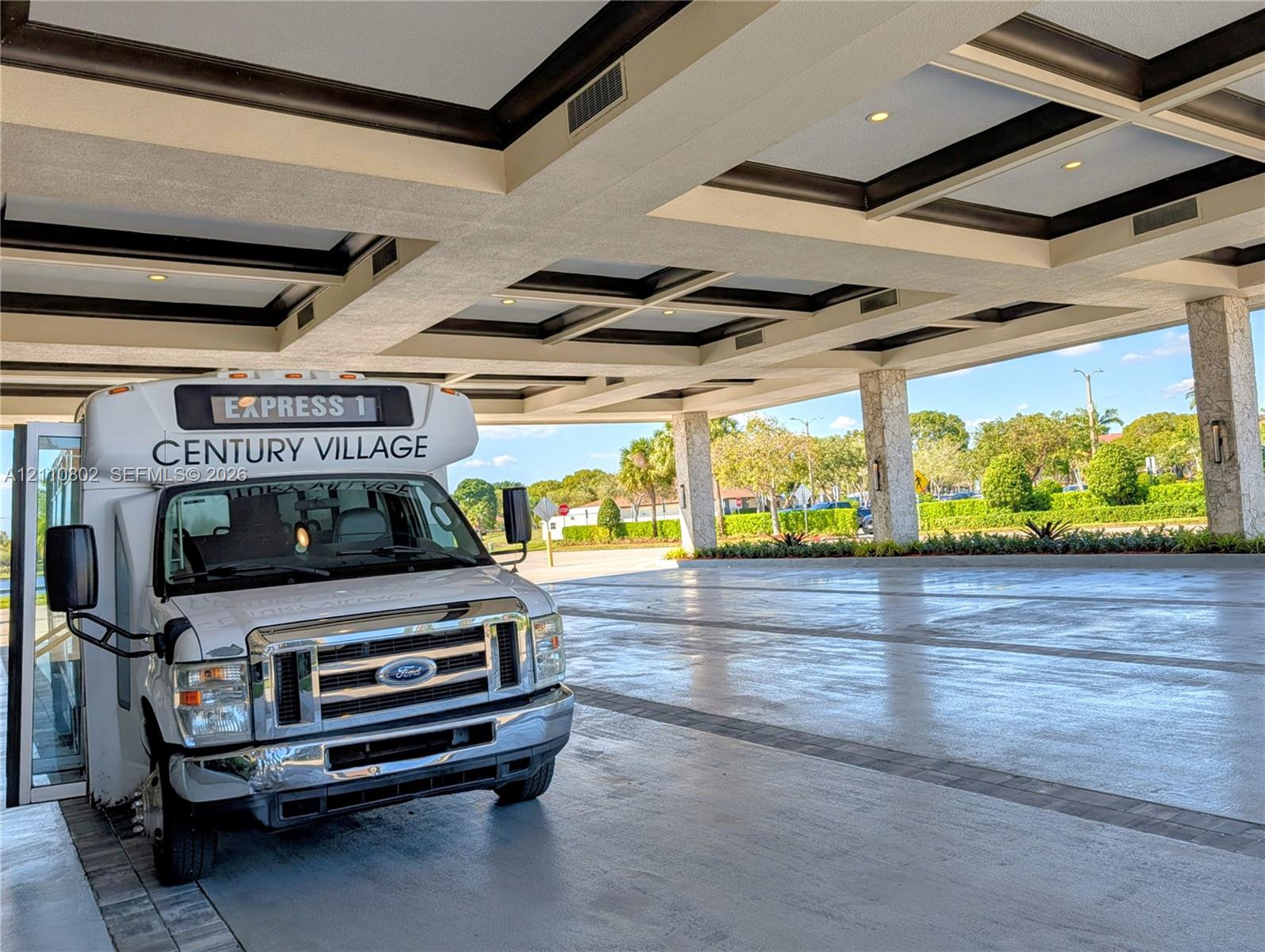 Covered porte-cochere featuring a coffered ceiling, stone-clad pillars, and recessed lighting