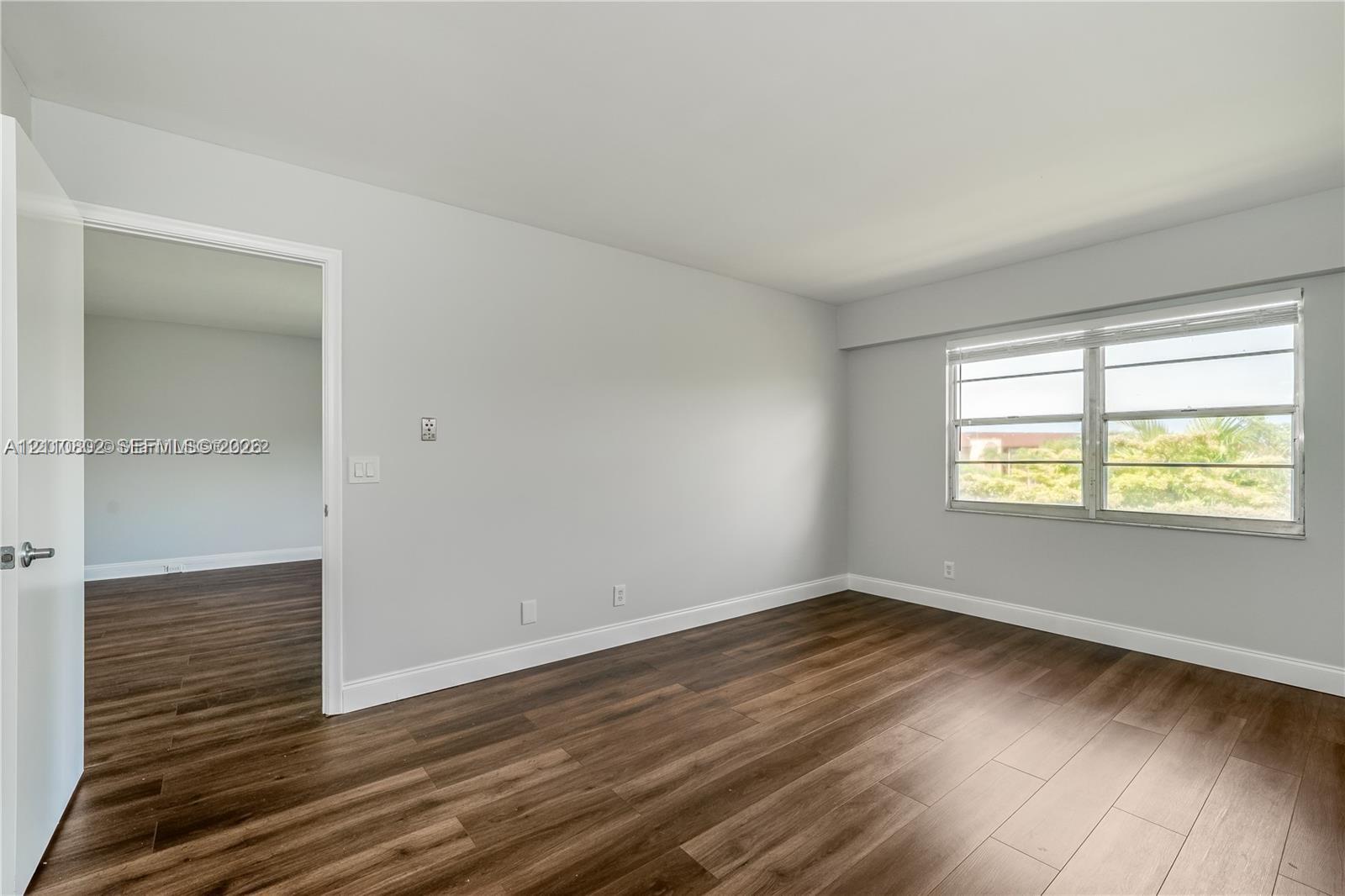 Interior room featuring neutral wall paint, wood-finish flooring, and horizontal sliding windows