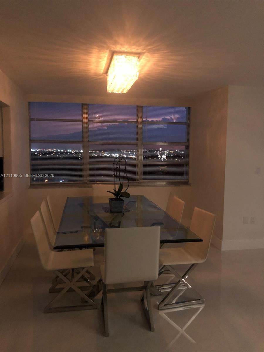 Expansive floor-to-ceiling windows, rectangular flush-mount ceiling lighting with textured detailing, and polished stone-finish flooring