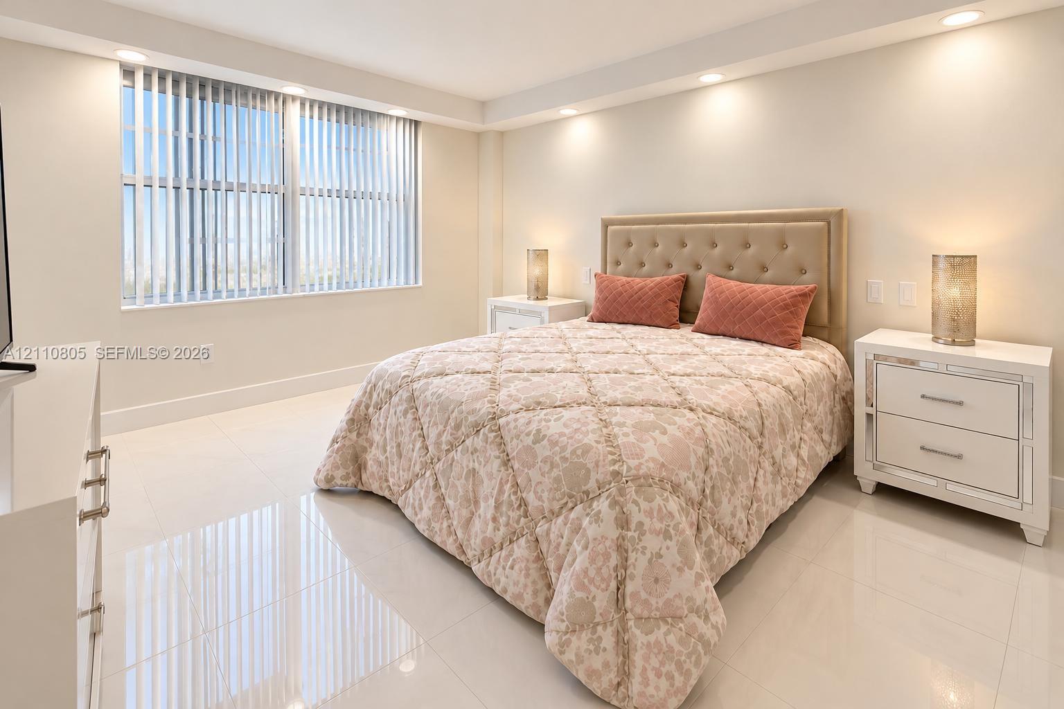 Large-format tile flooring, recessed ceiling lighting, and expansive window with vertical blinds