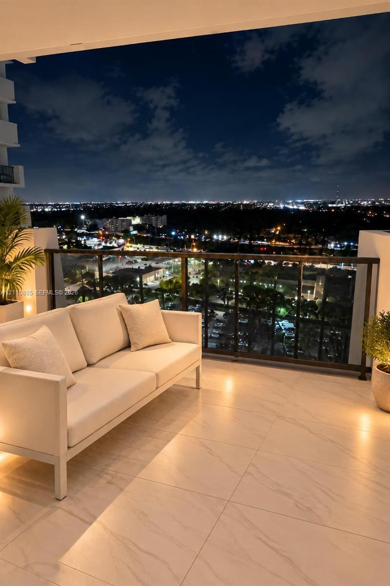 Covered balcony featuring large-format porcelain tile flooring and a sleek metal railing with glass panels
