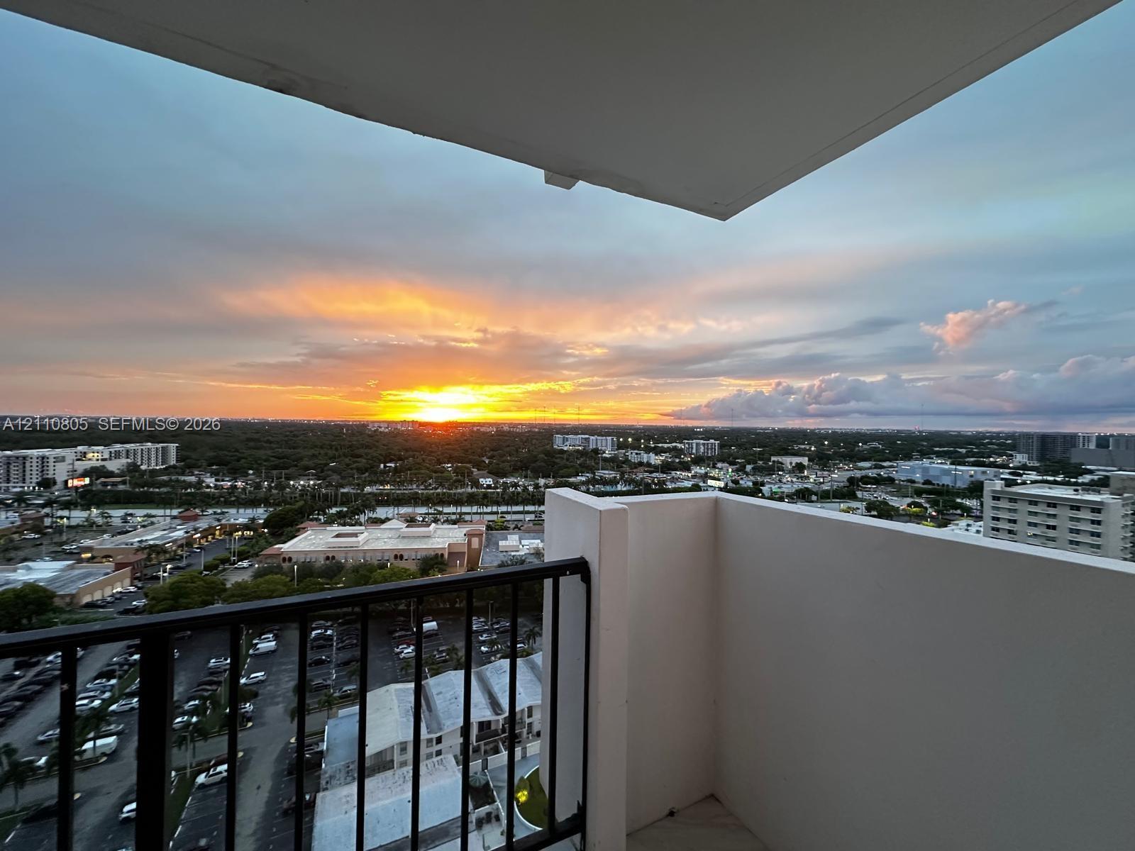 Private balcony featuring black metal railings and overhead coverage, showcasing expansive panoramic scenery Private balcony featuring black metal railings and overhead coverage, showcasing expansive panoramic scenery