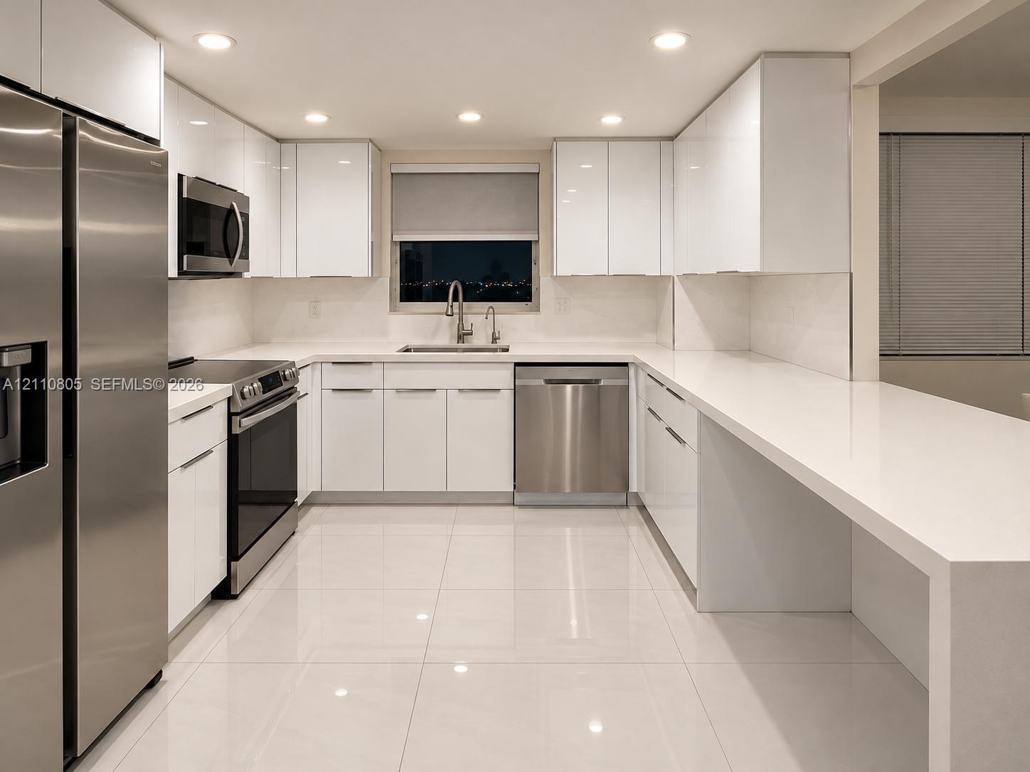 Kitchen featuring white gloss cabinetry, stainless steel appliances, solid surface countertops, recessed lighting, and tile flooring Kitchen featuring white gloss cabinetry, stainless steel appliances, solid surface countertops, recessed lighting, and tile flooring