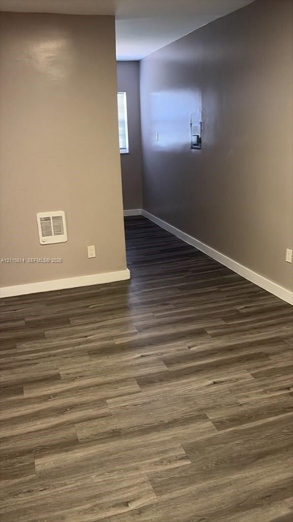 Wood-finish flooring, neutral wall tones, and an integrated wall-mounted heater