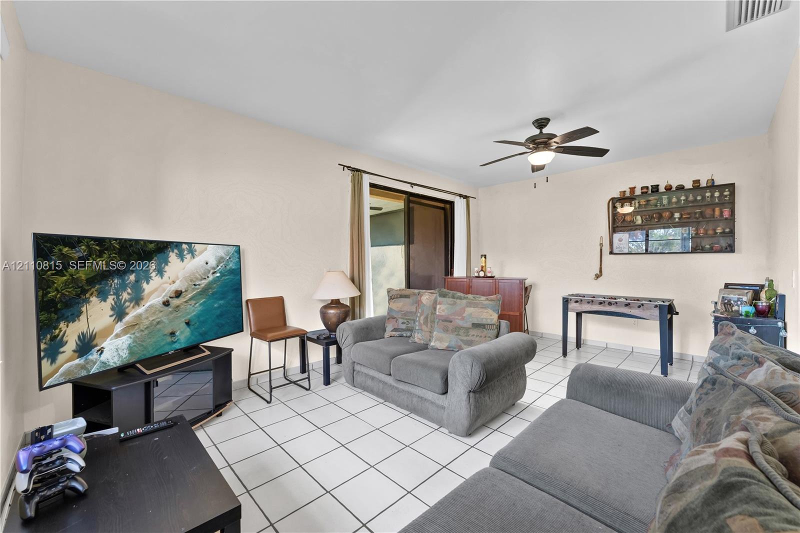 Ceramic tile flooring, ceiling fan with integrated lighting, and sliding glass door