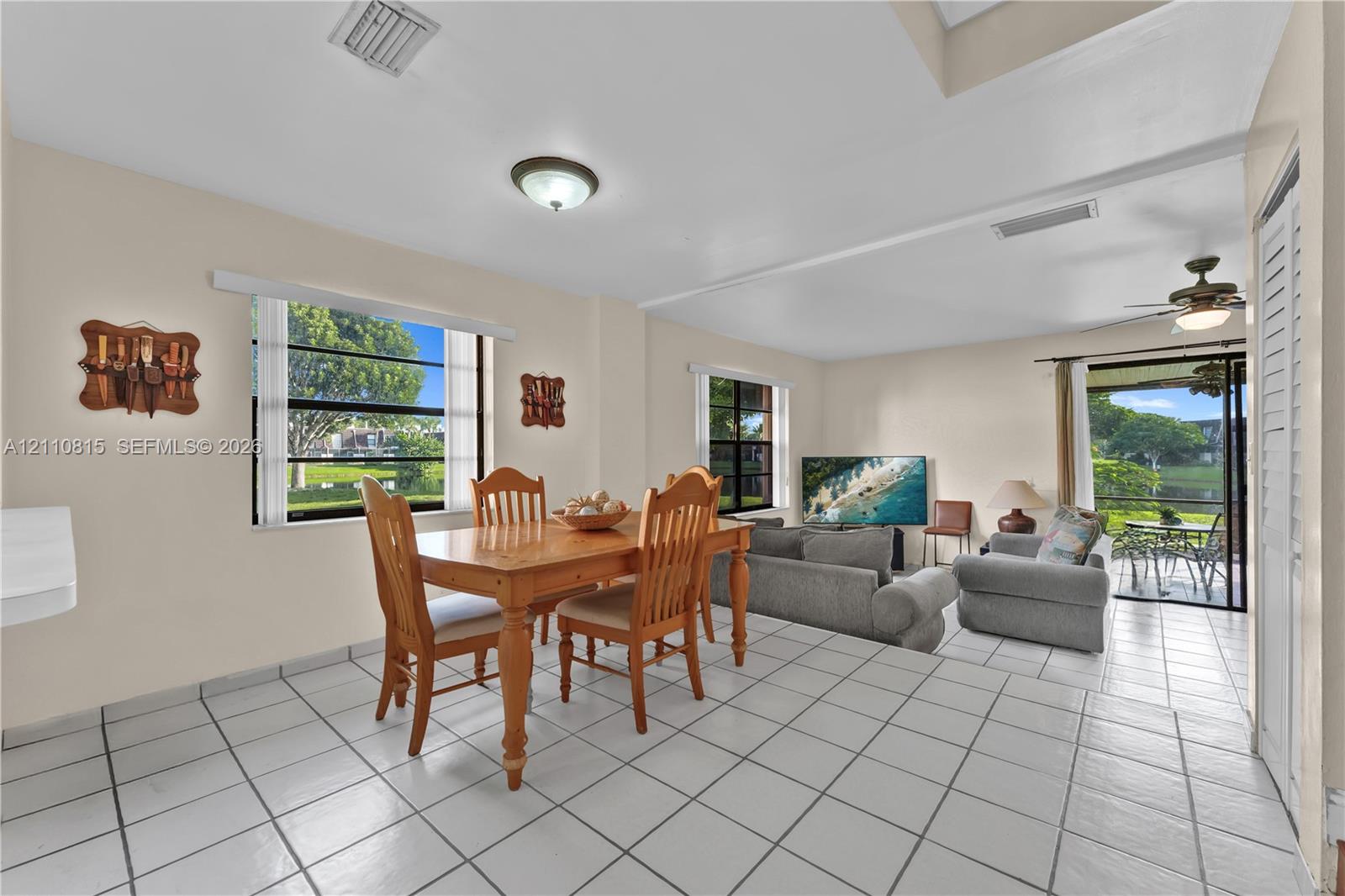Living area featuring tile flooring, ceiling fans, recessed lighting, and multiple windows providing natural light, inclusive of a sliding glass door to exterior space
