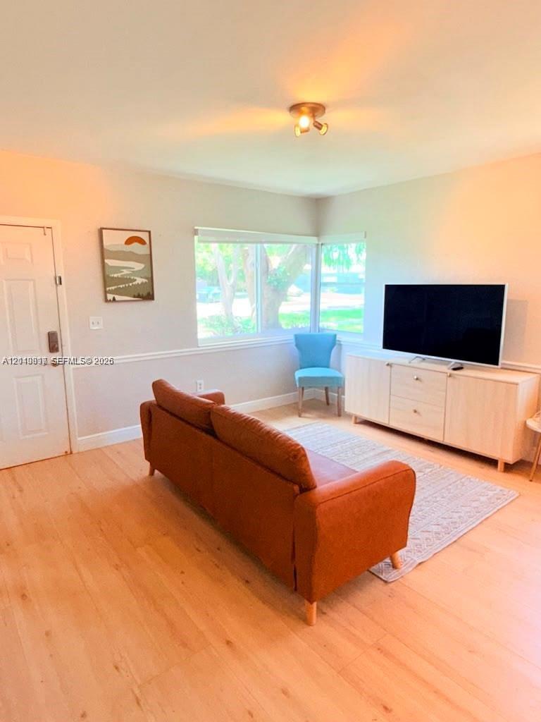 Wood-finish flooring, light-colored walls, horizontal-pane windows, and neutral-toned chair rail molding