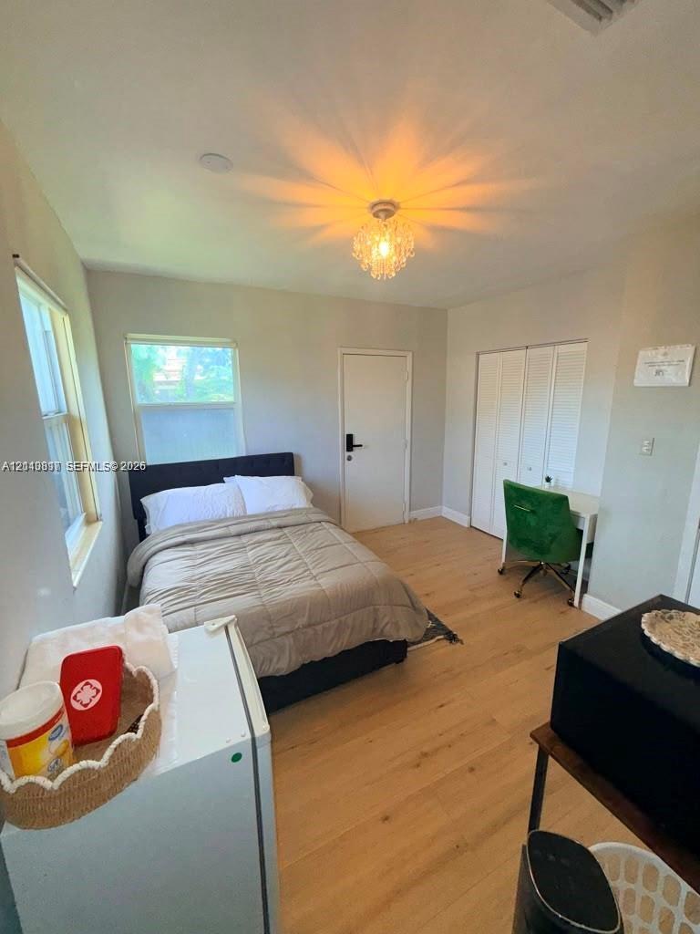Wood-finish flooring, dual windows, recessed lighting fixture, and white bifold closet doors