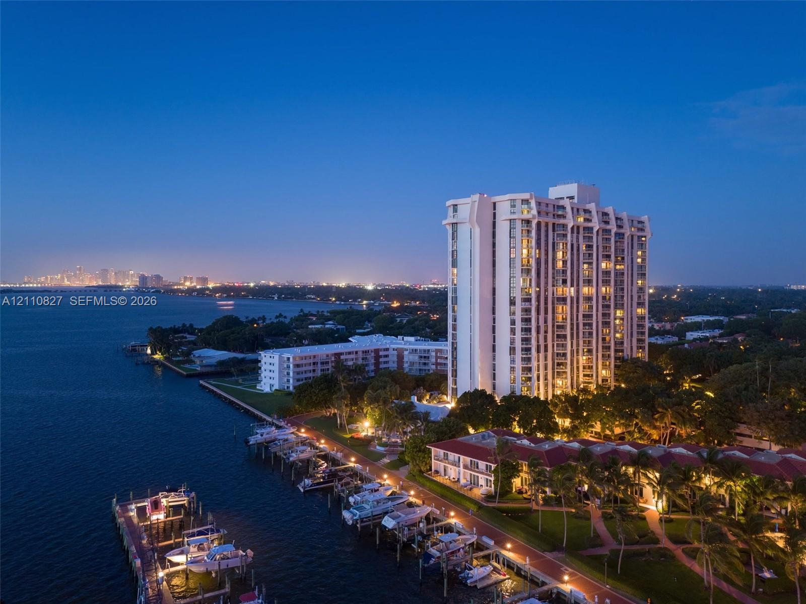 High-rise residential building featuring waterfront positioning, private boat slips, extensive landscaped grounds, and paved pathways