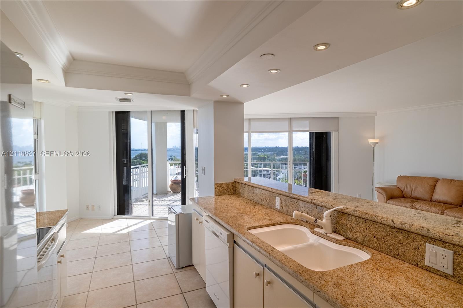 Kitchen featuring stone countertops, a dual-basin undermount sink, white cabinetry, tile flooring, and recessed ceiling lighting