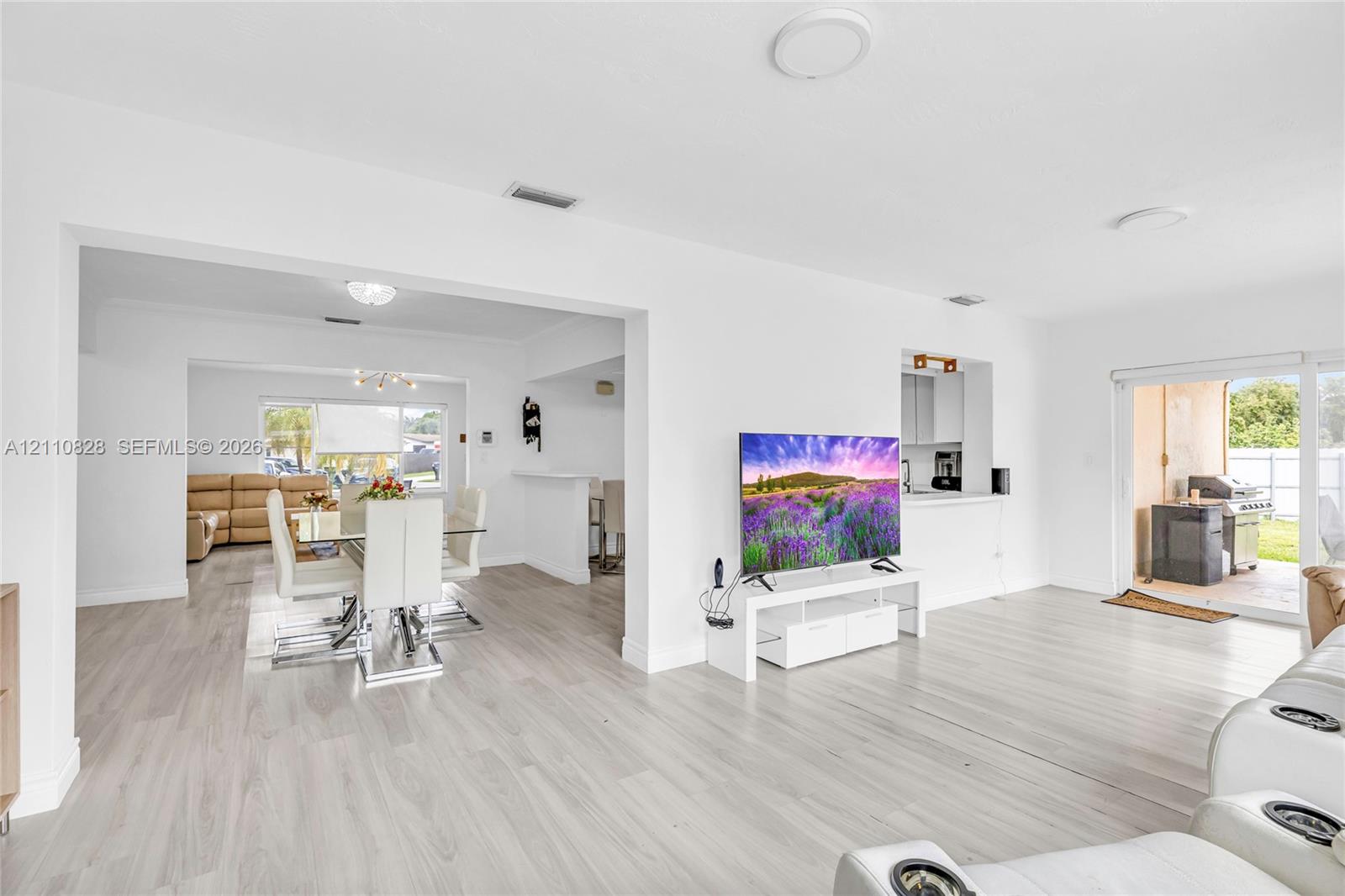 Open-concept interior featuring wood-finish flooring, recessed lighting, and sliding glass doors providing outdoor access