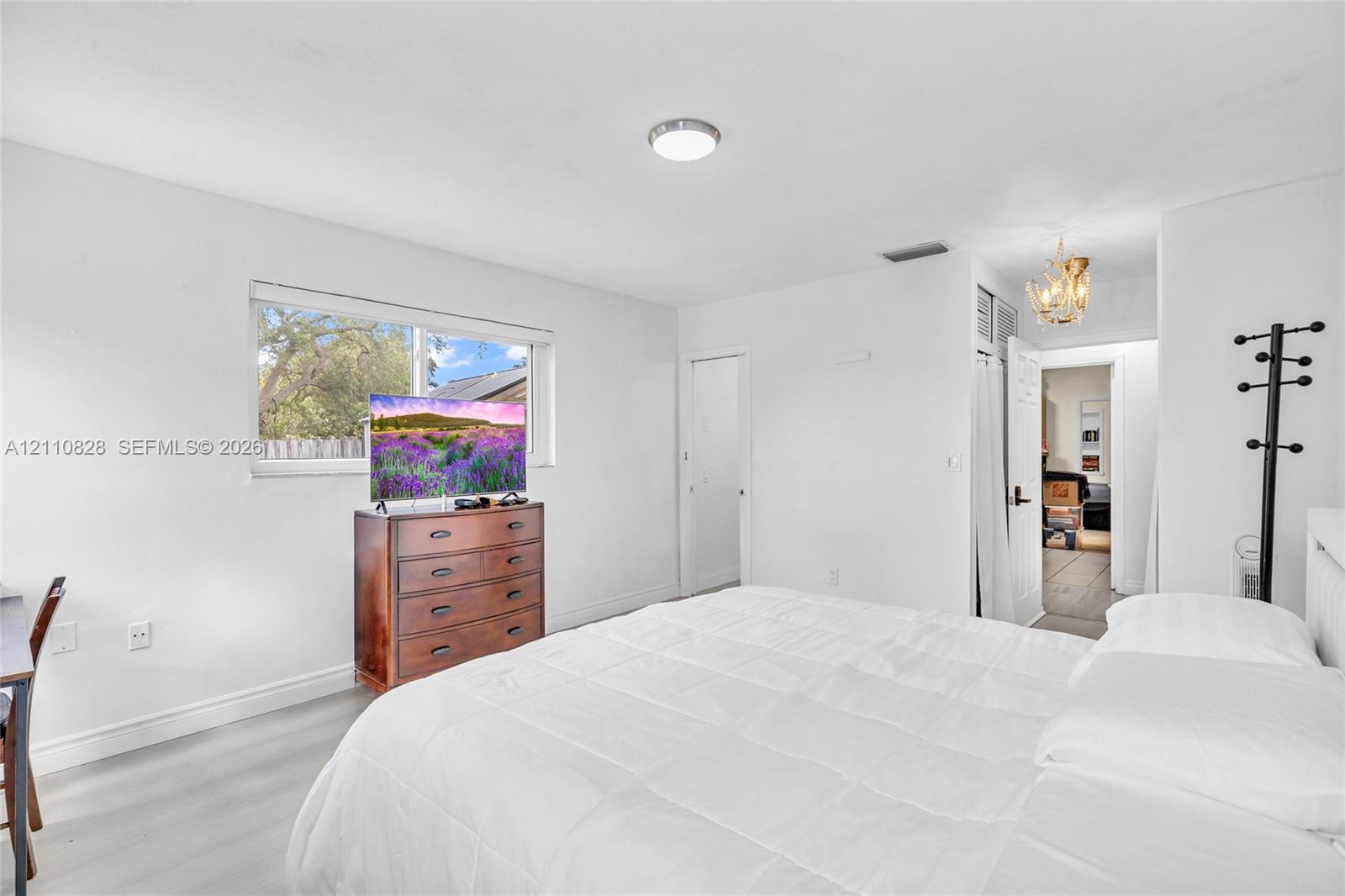 Neutral wall finishes, wood-finish flooring, recessed ceiling lighting, and a single-pane horizontal window