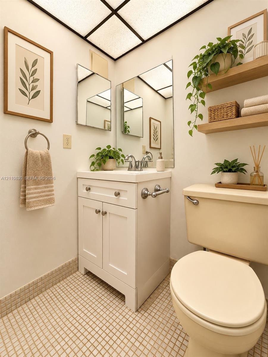 STAGED White vanity with cabinetry and integrated sink, chrome-finished hardware, frameless wall mirror, and grid-pattern ceiling lighting