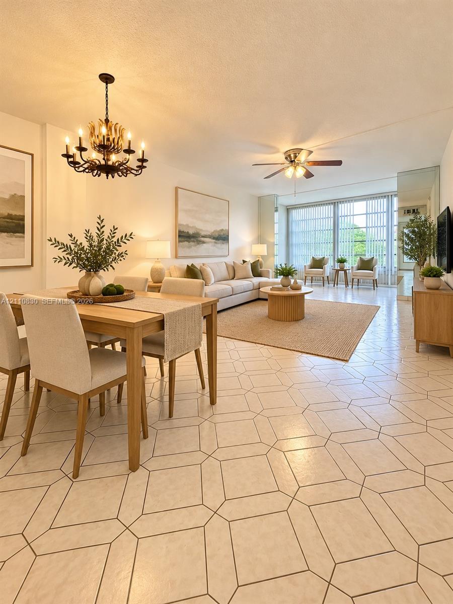 STAGED Open-concept area featuring geometric patterned tile flooring, a multi-arm metal chandelier, a ceiling fan with integrated lighting, and floor-to-ceiling windows STAGED Open-concept area featuring geometric patterned tile flooring, a multi-arm metal chandelier, a ceiling fan with integrated lighting, and floor-to-ceiling windows