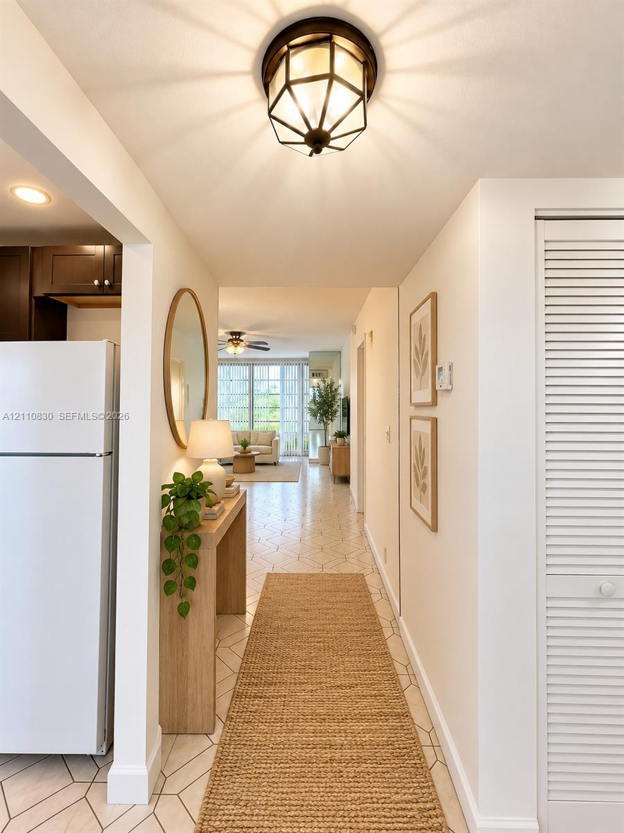 STAGED Hallway featuring geometric tile flooring, a multi-faceted flush-mount light fixture, and floor-to-ceiling louvered closet doors STAGED Hallway featuring geometric tile flooring, a multi-faceted flush-mount light fixture, and floor-to-ceiling louvered closet doors